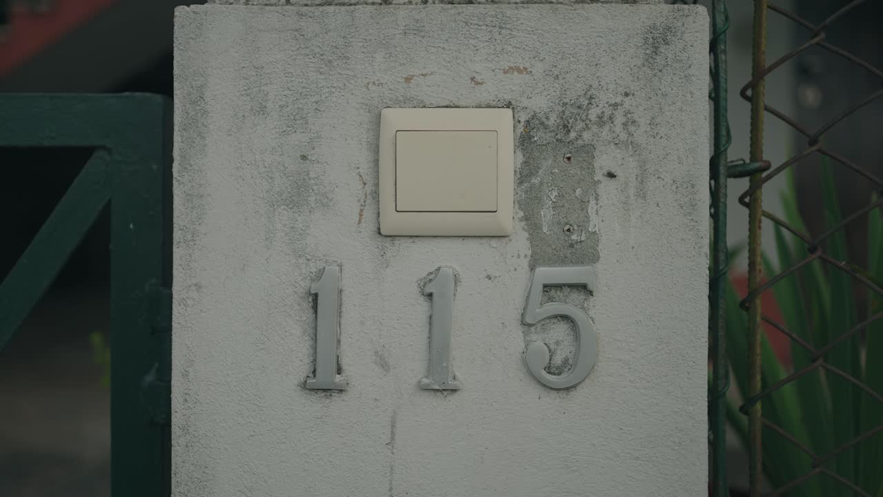 Primer plano del número de una casa desgastado sobre una superficie de hormigón texturizado