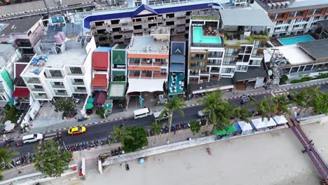 aerial footage captures vibrant beachfront buildings and bustling street activity in patong, phuket, showcasing colorful architecture and lively atmosphere
