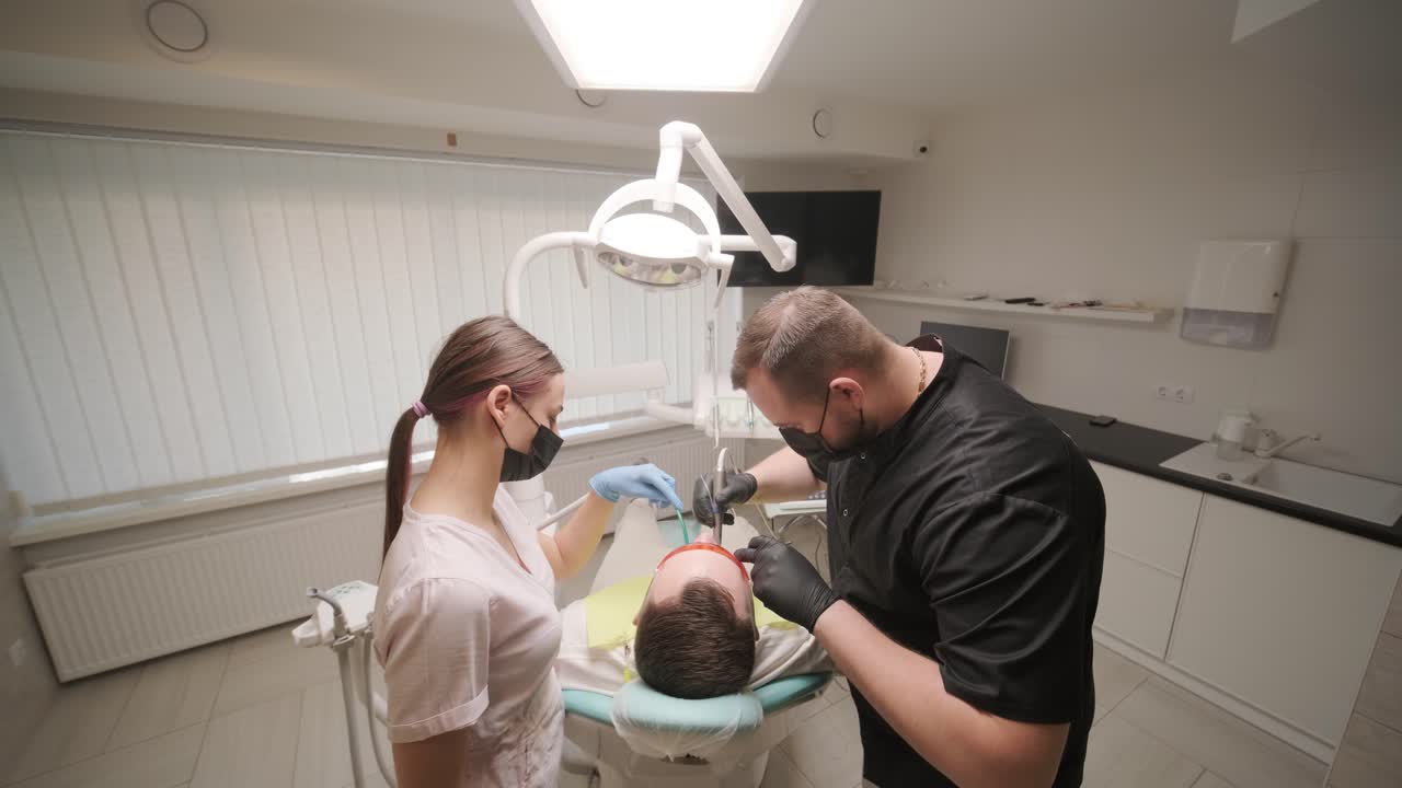 dentista que realiza un procedimiento dental en el paciente