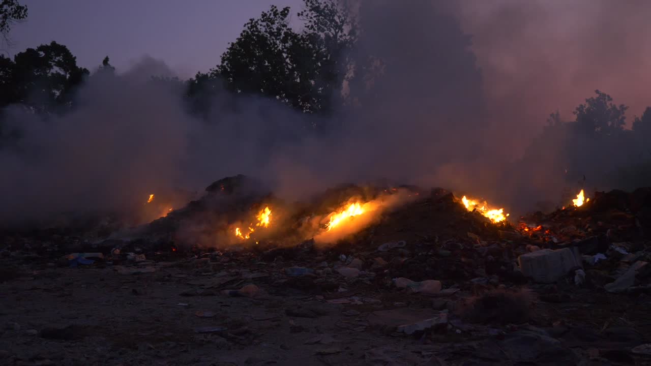 Il sole tramonta in India mentre la spazzatura brucia in una discarica su un'isola nel Mar delle Andamane.