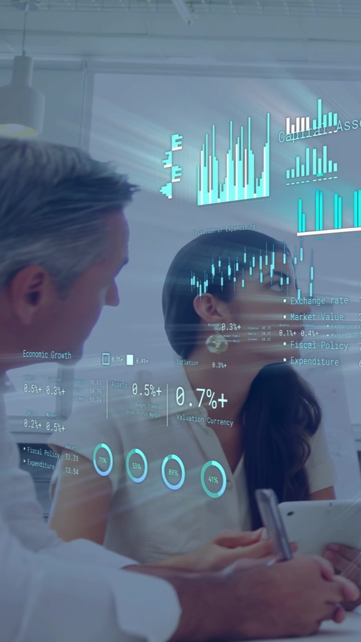 Vertical video: Woman tapping tablet, man leaning, holographic charts pulsing rates for business