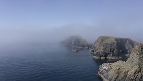 La-Antena-De-La-Costa-Vuela-Hacia-La-Niebla-De-La-Tarde-En-Los-Islotes-De-Rocas-Oceánicas-Dentadas