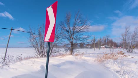 snow drifts form on country roads as strong winds sweep over flat farmland creating dangerous winter driving conditions