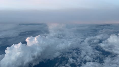 cockpit view, dawn- high altitude cruising over cumulonimbus and altocumulus clouds