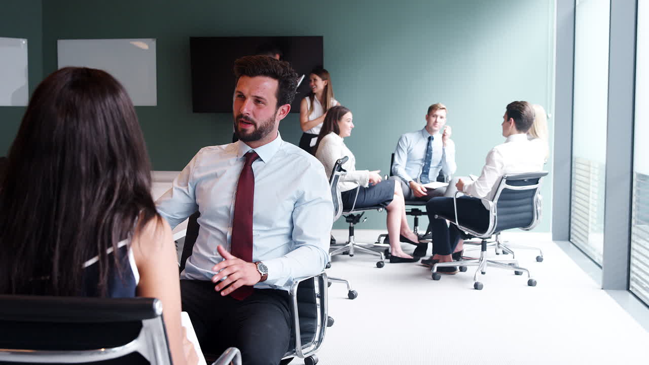 grupo que colabora en una tarea en el día de evaluación de la contratación de graduados mientras es observado por el equipo de contratación