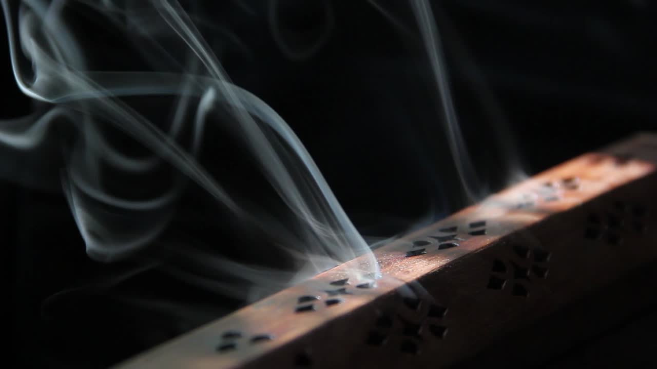 el humo del incienso sale lentamente de un quemador de incienso de madera