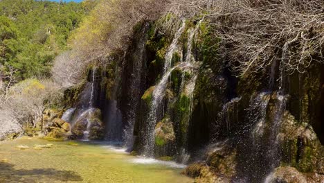 cascadas de aguas puras y vegetación de colores verdes y amarillos durante el deshielo de primavera