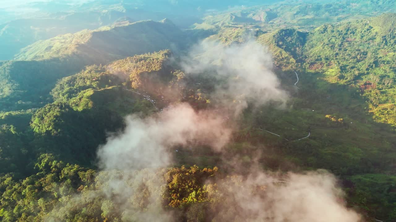 Aerial drone footage of clouds drifting over lush green Philippine mountains and valleys, creating a cinematic and atmospheric natural scene