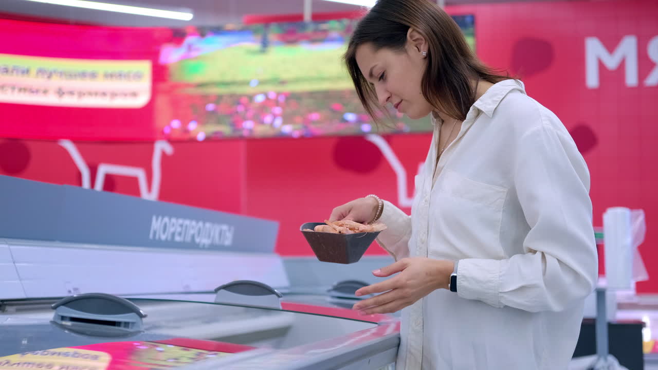 食料品店でエビを買う女性