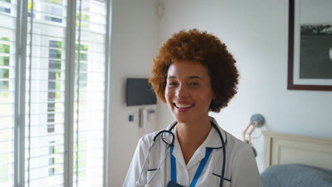 Portrait-Of-Smiling-Female-Nurse-Wearing-Uniform-With-Digital-Tablet-In-Private-Hospital-Room