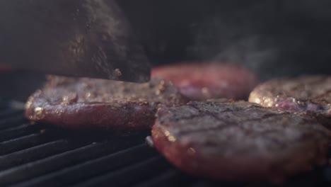 una toma de cerca de una hamburguesa jugosa volviendo en la parrilla