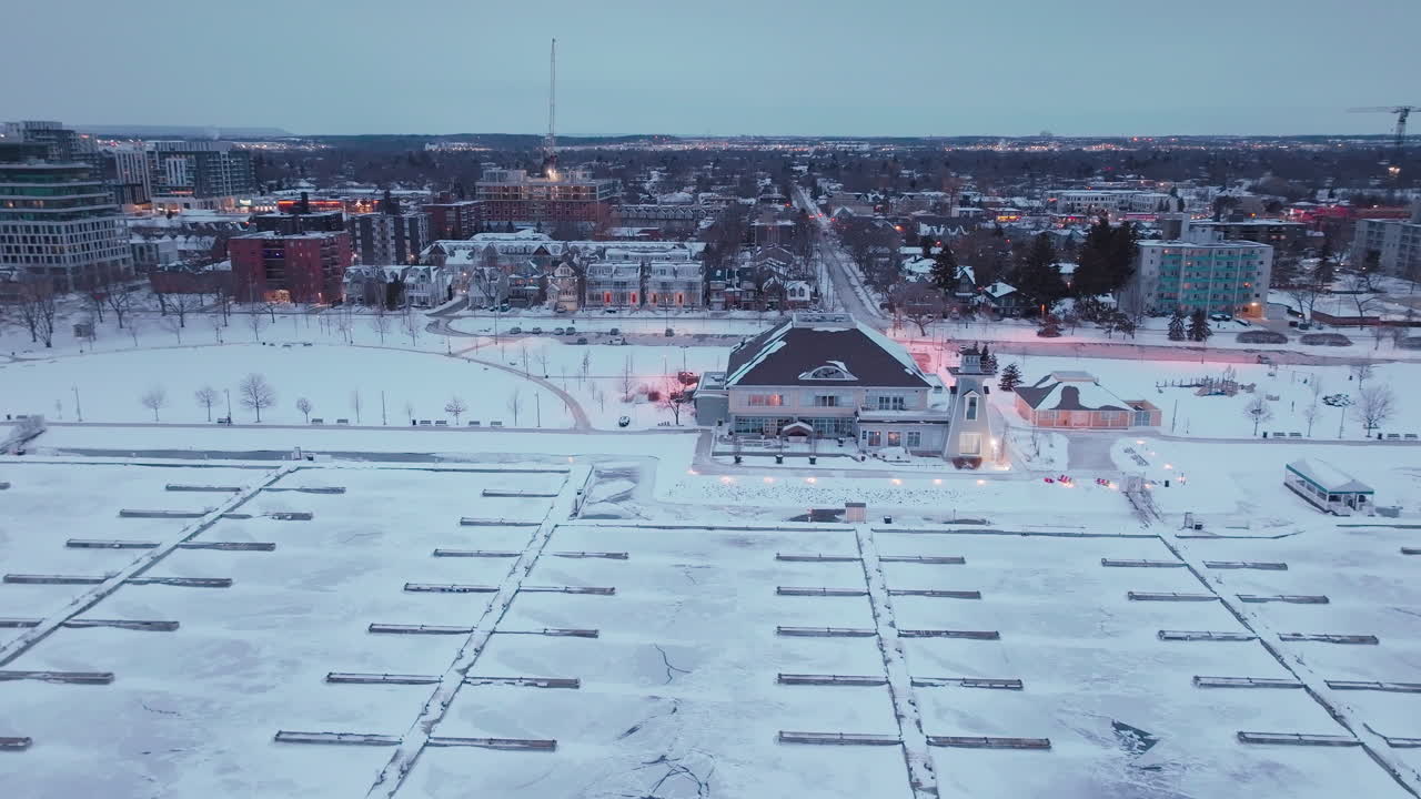 Lumisen Bronte Harbourin näkymä jäätyneen Ontariojärven yli hämärässä talvella.