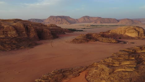 wadi rum red desert landscape at sunset, jordan, aerial pull away