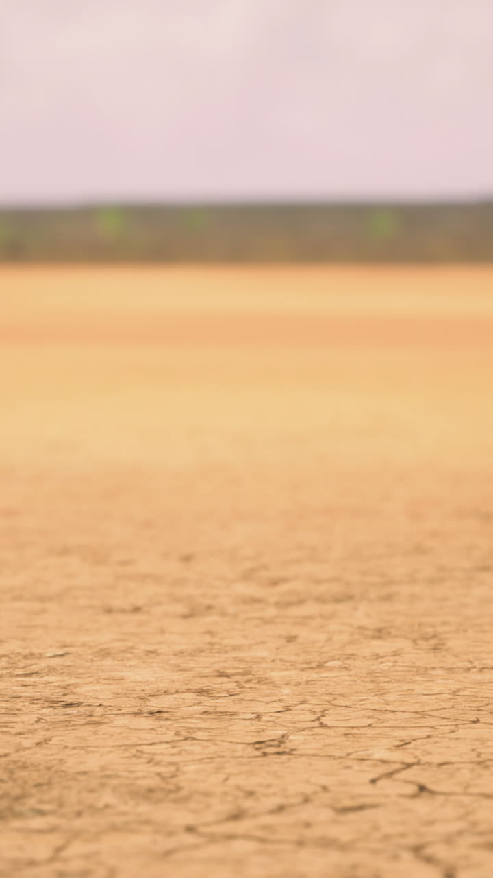 Dry cracked earth under a cloudy sky in a remote landscape during daytime