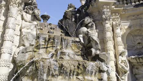 a fountain in front of a building with statues on it