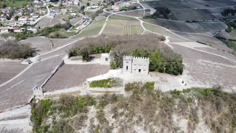 círculo de drones alrededor de un bonito y pequeño castillo suizo en una pequeña colina en valais, cerca de sierre