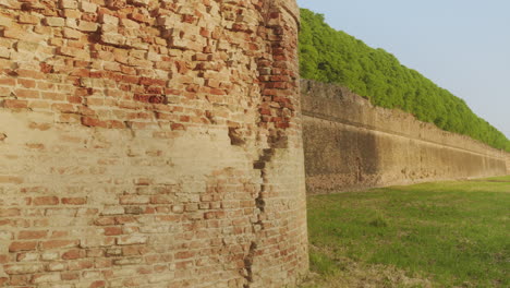 pan right medium shot of ferrara's historic city walls with clear sky during a beautiful sunny day