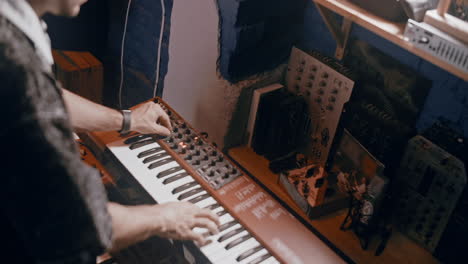 musician playing synthesizer in home studio