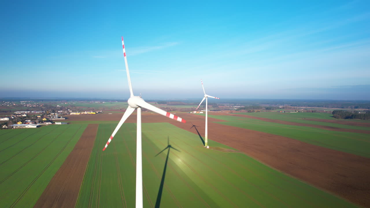 푸른 하늘 을 가진  ⁇ 빛 이 있는 날 에 회전 하는 풍력 터빈 의 공중 사진 - 재생 가능 에너지 를 생산 하는 것