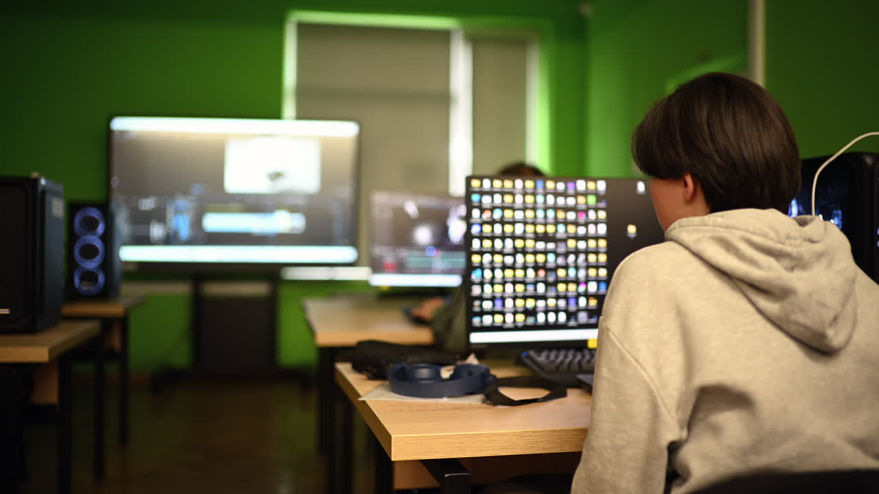Chisinau, Moldavia - 15 marzo 2026: Giovane studente seduto al computer in un'aula moderna con più monitor