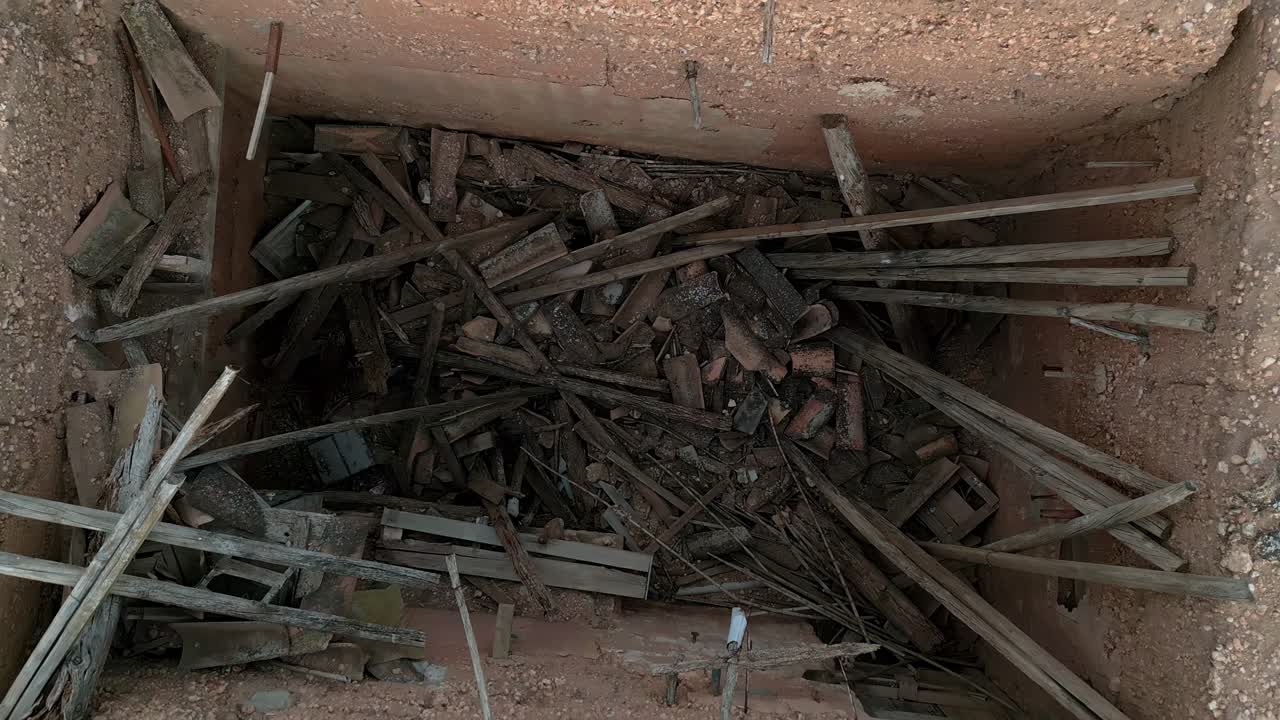 ojo de pájaro aéreo que se eleva desde un cobertizo de herramientas abandonado con escombros y sin techo, españa