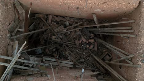 aerial birdseye rising from abandoned tool shed with debris and no roof, spain