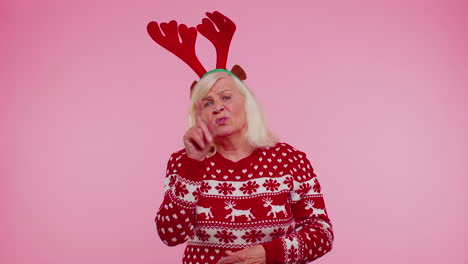 angry old woman in christmas deer antlers raising hands in indignant expression quarreling conflict