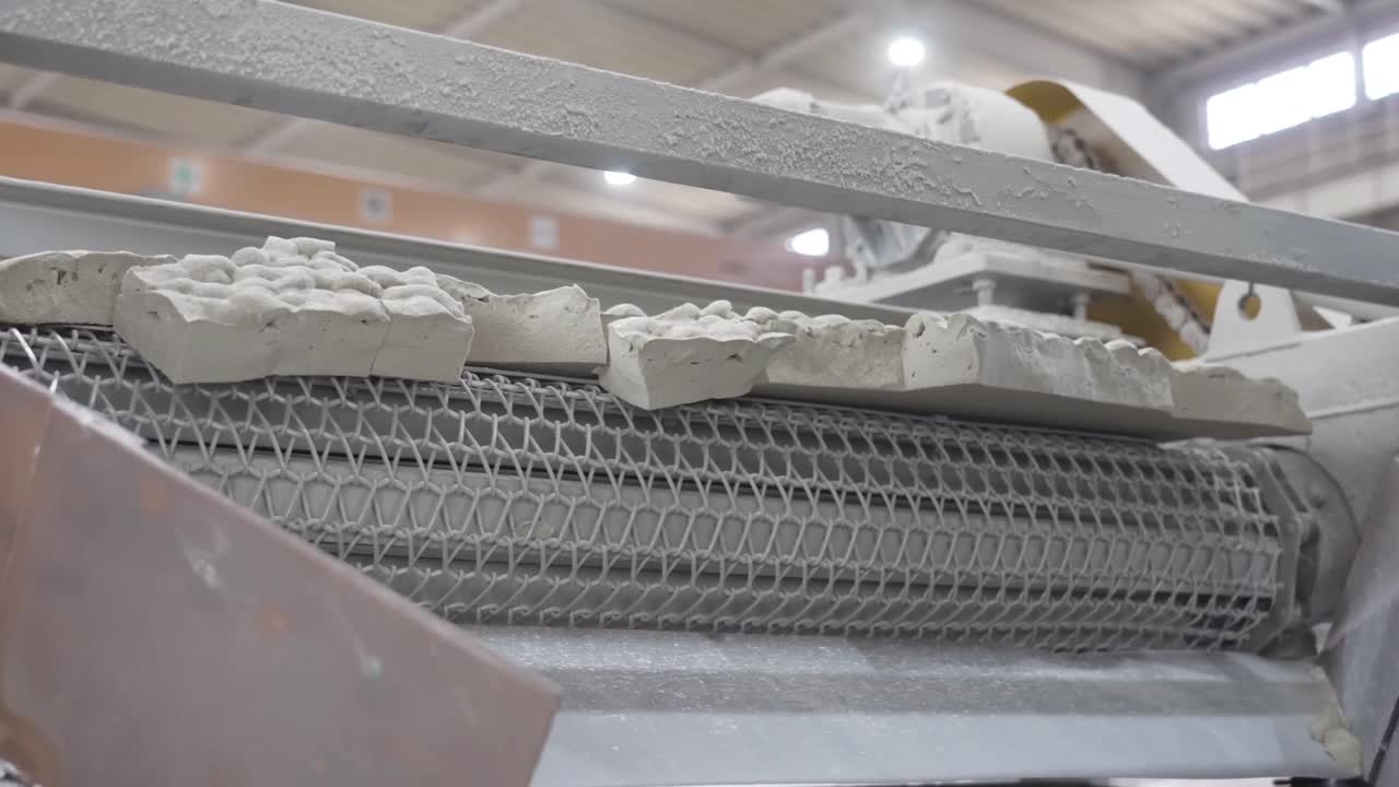 Stone materials are fall on conveyor belts. The process of converting glass into a stone-like material.