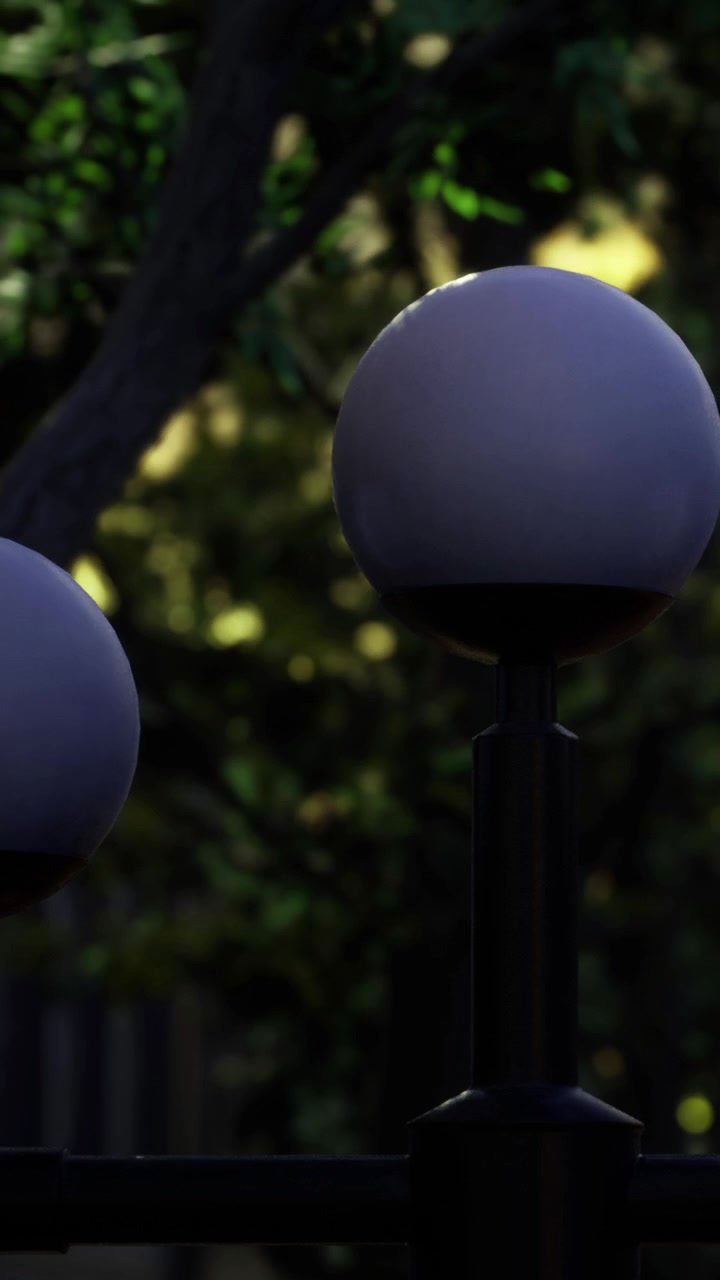 Lighting fixtures stand among trees in a park during evening hours