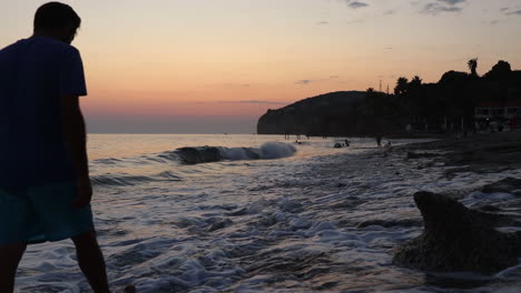 Junger-Mann-Zu-Fuß-Am-Strand-Sonnenuntergang