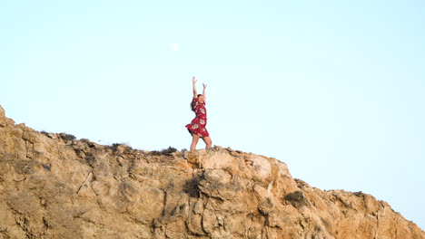 woman on a cliff at sunset