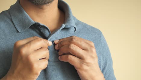 man putting on polo shirt