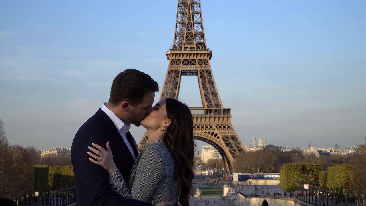 Coppia romantica caucasica che si bacia a Parigi, con la Torre Eiffel sullo sfondo all'ora d'oro, uomo d'affari caucasico in abito