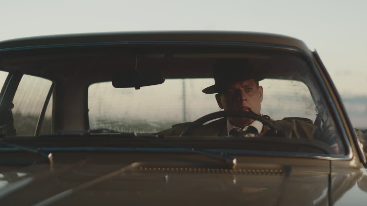 hombre conduciendo un coche de época