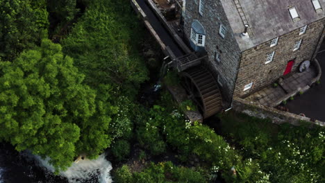 aerial shot of disused stone mill building located in picturesque bushmills, northern ireland