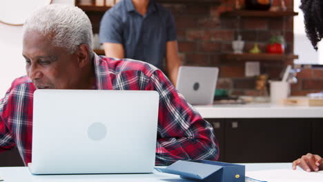 Children-Doing-Homework-In-Busy-Multi-Generation-Family-Home