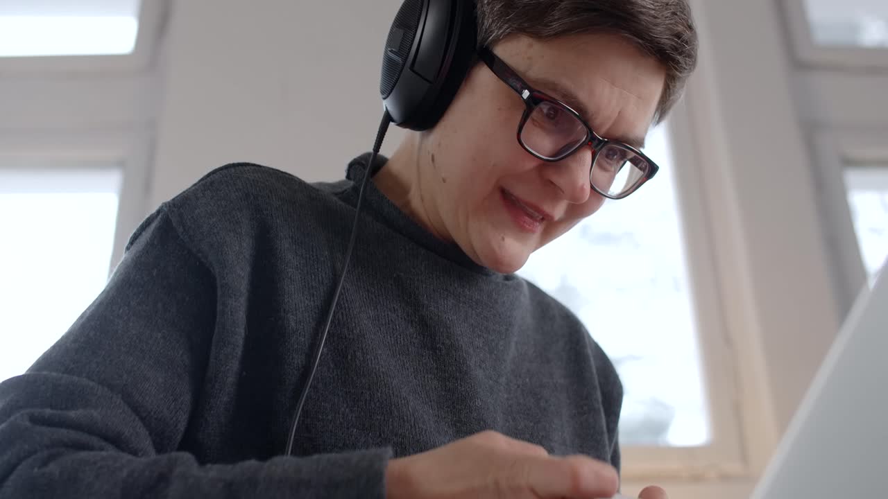 Woman working on laptop with headphones