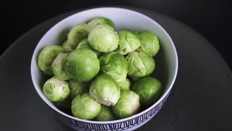 fresh and wet brussel sprouts rotating on black background, 4k