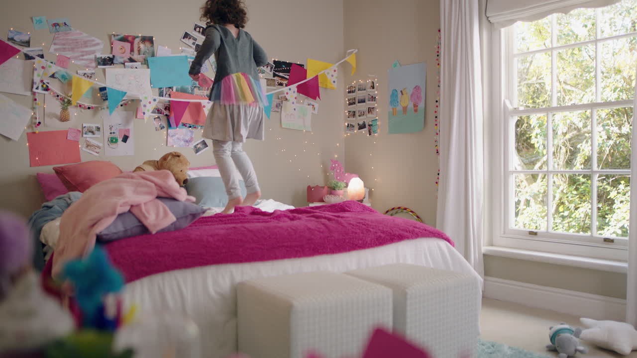 счастливая маленькая девочка танцует на кровати, веселится, ребенок в игривом настроении, наслаждается выходным утром дома.