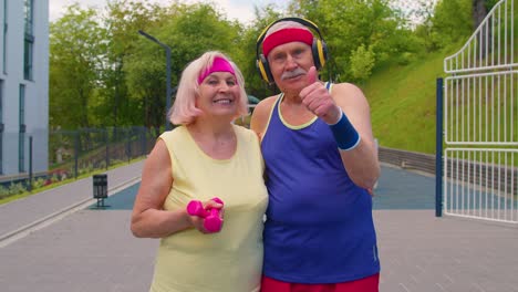 Active-elderly-man,-woman-after-sport-weightlifting-dumbbells-exercises,-smiling-looking-at-camera