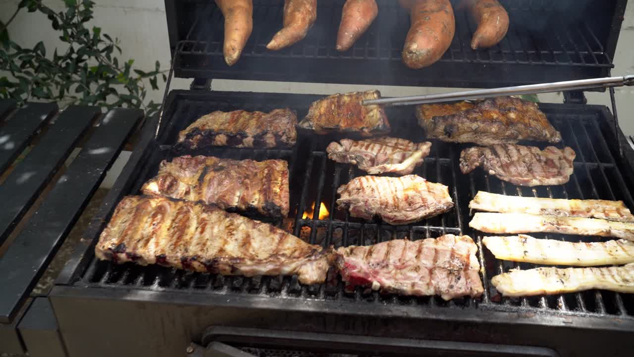 요리사 맛있는 갈비 돼지고기를 바베큐 그릴에서 요리합니다. 맛있는 그릴 돼지 요리 bbq