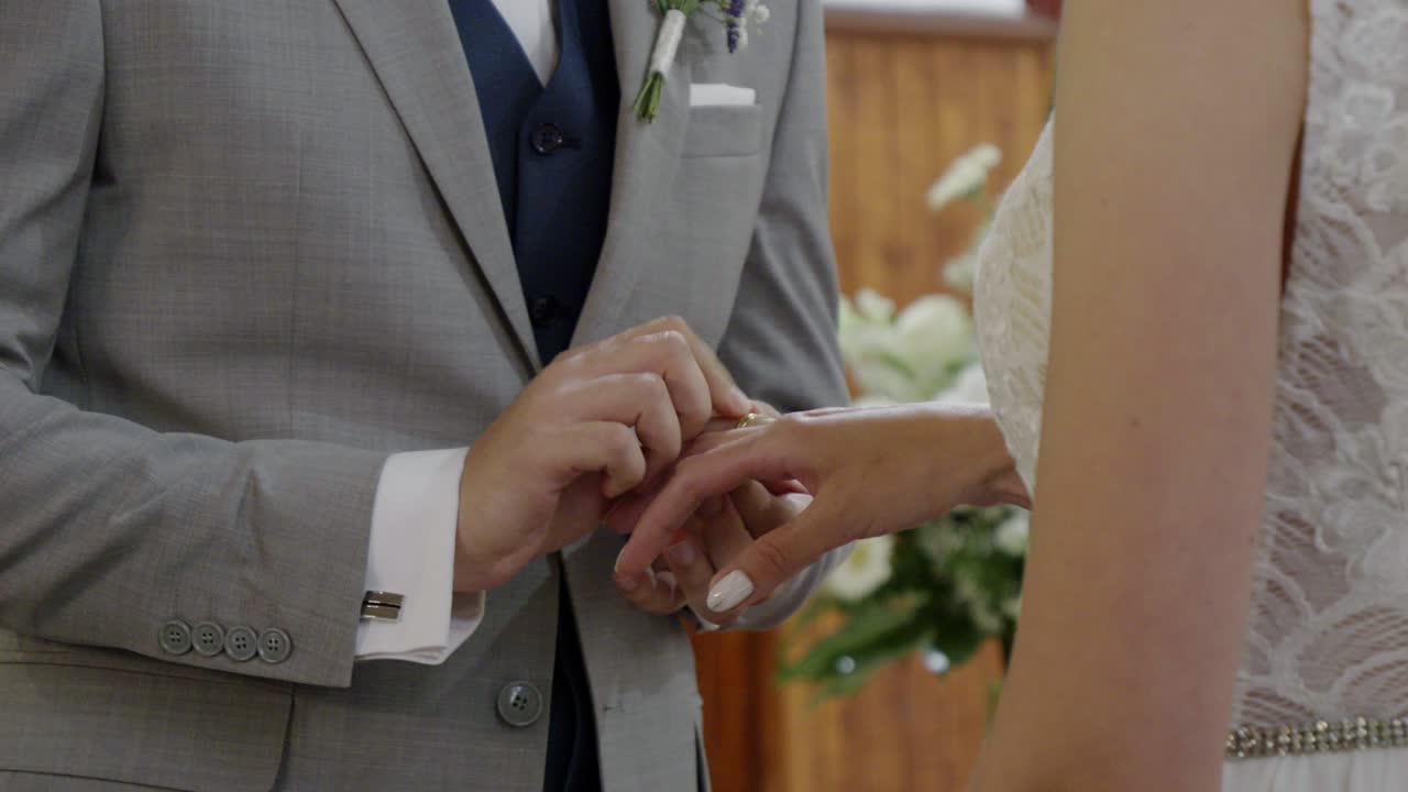 Cerimonia nuziale. Lo sposo mette la fede al dito della sposa mentre recita le promesse di matrimonio