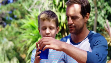 Padre-Dando-Un-Vaso-De-Agua-A-Su-Hijo-En-El-Jardín