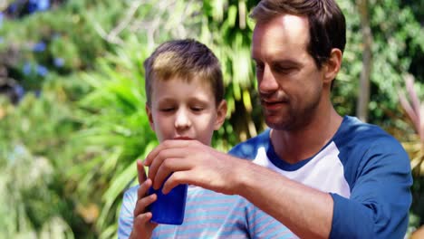 padre dando un vaso de agua al hijo en el césped del jardín