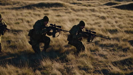 soldiers in camouflage uniforms carrying rifles in a field