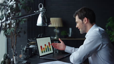 Businessman-analyzing-graphs-on-laptop-screen-in-office.-Man-working-on-laptop