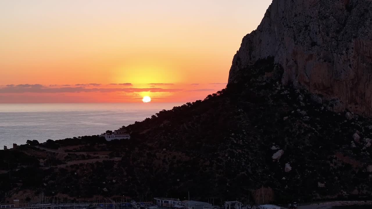 Vista aérea de um belo pôr do sol sobre uma falésia rochosa perto de um local costeiro tranquilo com o hotel Estimar, em Calpe, Alicante, Espanha.