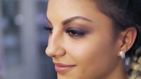 close up of attractive young woman with beautiful makeup smiling at camera