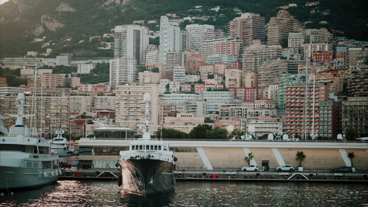 View of boats docked in the Monaco Marina with the skyline of the city on the background