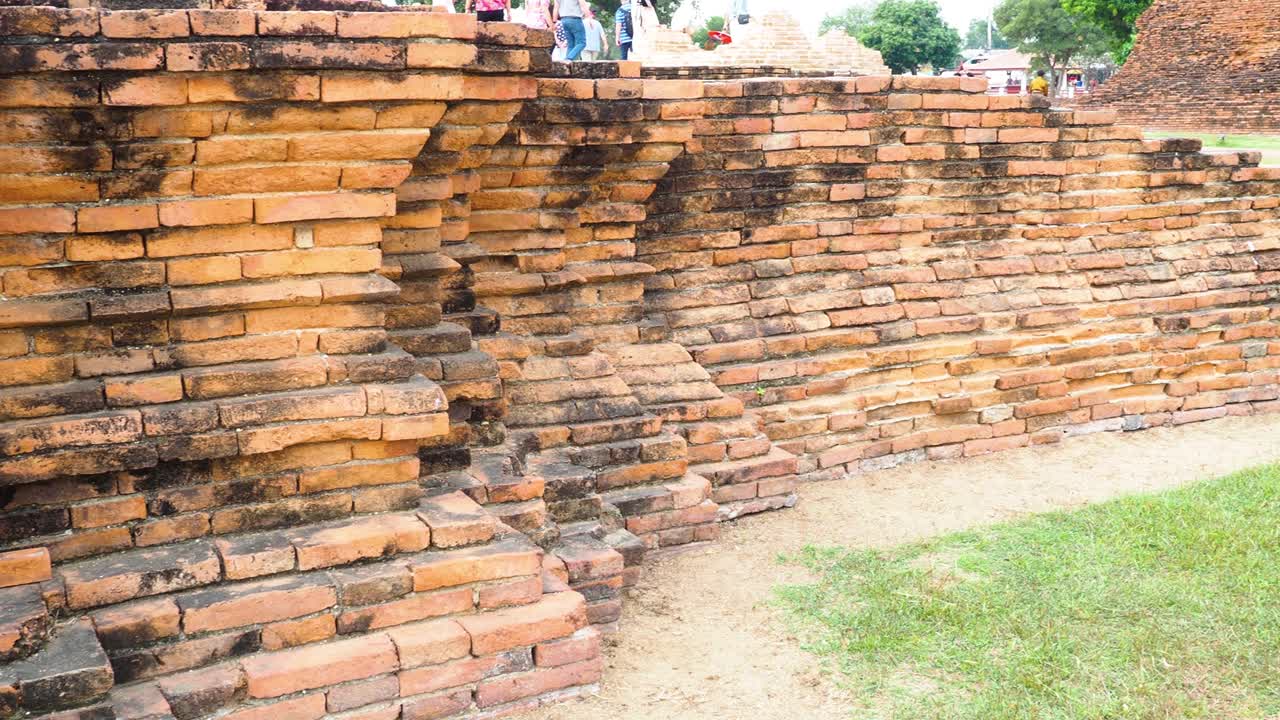역사적인 아유타야 유적지에 있는 벽돌 벽과 관광객들